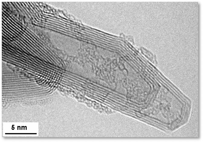 A karbonszál hosszmetszetéről készült elektronmikroszkópos felvételen jól kivehetőek az egymásba göngyölt rétegek<br><small><a href=http://w3.rz-berlin.mpg.de/ac/imageofthemonth/2005.html target=_blank> w3.rz-berlin.mpg.de/ac/imageofthemonth/2005.html</a></small>