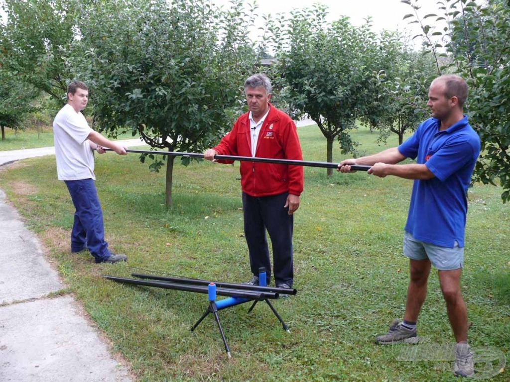 A két segítő így helyezkedik el, miközben széthúzni próbálják a bottagokat