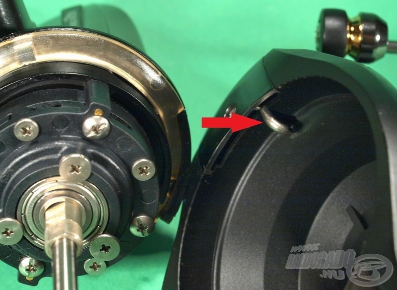 A csészefék lényege az az áttetsző, rugalmas műanyag gyűrű, amely a rotor alatt, az orsó vázán helyezkedik el. Erre a gyűrűre lép rá a kinyitott felkapókar átváltó rúdja (piros nyíl), így a dobás lendületétől nem fordulhat el a rotor, és nem csapódhat vissza akaratlanul a felkapókar